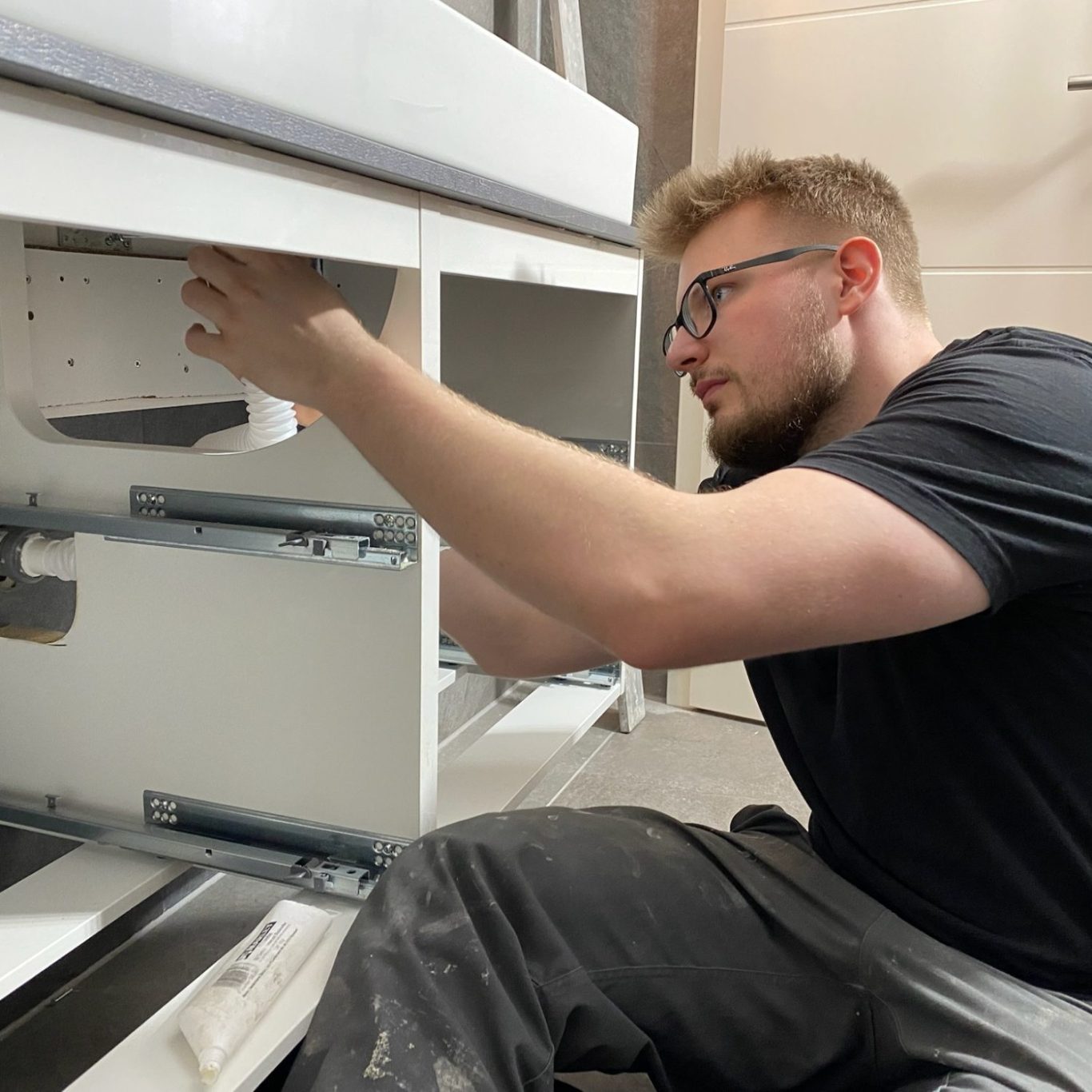 Reparatur und und Instandhaltung Ihrer Immobilie Handwerker beim Wechsel eines Waschbecken-Siphons im Badezimmer